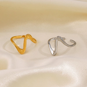 Minimalist wavy open rings in gold and silver finish on elegant beige silk fabric