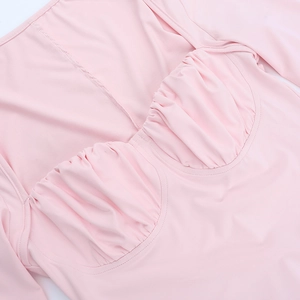 Close-up of pink sexy mini dress showing pleated bust detail and elastic fabric texture