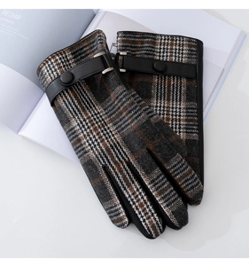 Detailed close-up of British plaid gloves with brown wool fabric and black leather wrist strap