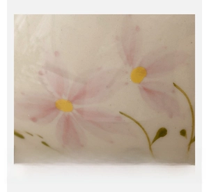 Macro detail of hand-painted pink flower patterns on ceramic teacup glaze