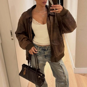 Détails d'une veste en cuir marron vieilli avec col vintage et texture rétro élégante