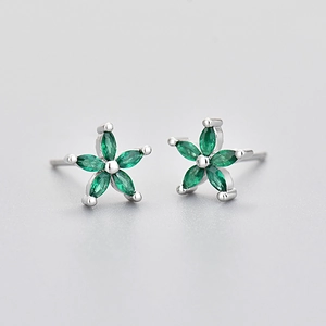 Macro view of flower studs featuring marquise green stones and silver finish