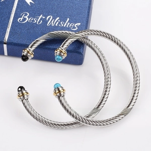 Detail of cable wire bracelets featuring twisted texture and inlaid colored gemstones