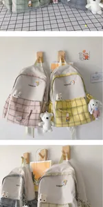 Detail of plaid backpacks with Changyue embroidery and cute plush animal charms