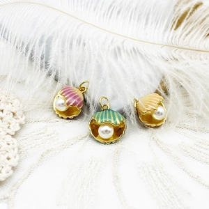 Detailed macro view of 18K gold plated shell charms with colorful enamel and pearls