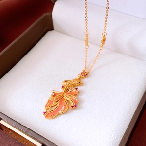 Macro view of detailed goldfish pendant with red enamel and pavé stones in a jewelry box