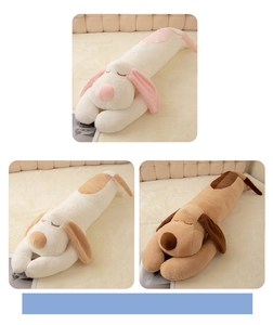 Close-up of three soft plush dog pillows in white, pink and brown in a cozy bed setting