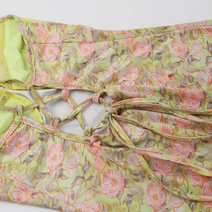 Détail du laçage croisé au dos d'une robe d'été à imprimé floral sur fond vert