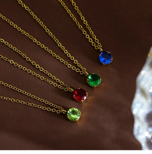 Macro shot of colorful round cubic zirconia pendants on golden stainless steel chains