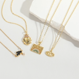 French vintage gold necklaces with butterfly and zircon pendants on stone background