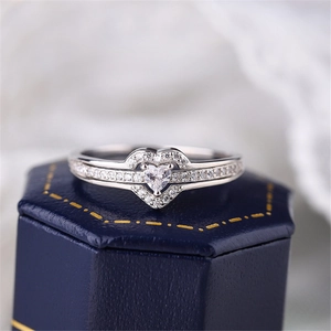 Macro shot of silver heart diamond ring on a velvet jewelry box showing fine metalwork