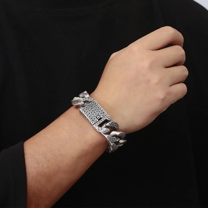 Detail of retro silver trident bracelet with heavy geometric patterns and square clasp