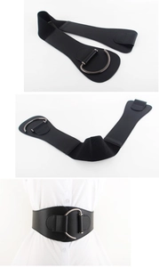 Detail of black wide waist belt featuring elastic band and large silver D-ring buckle