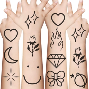 Detailed view of black outline temporary tattoos on skin featuring stars and hearts
