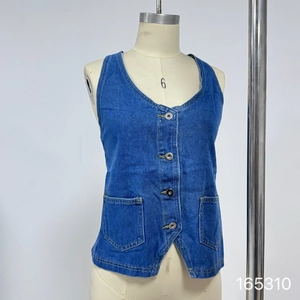 Detail of blue denim vest featuring four-button closure and dual symmetric pockets