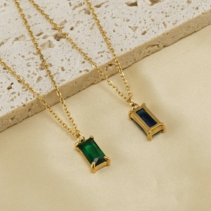 Detail of square zircon pendants in green and blue on gold stainless steel chains