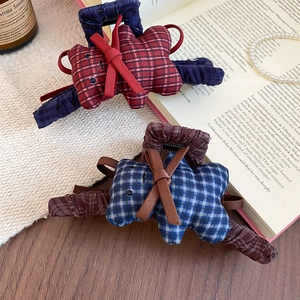 Detail of vintage plaid fabric bear hair claws with delicate ribbon bows on a book