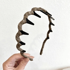 Close-up of coffee brown fabric headband with non-slip plastic teeth for hair styling