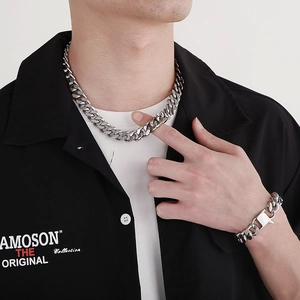 Men's polished silver Cuban link chain necklace and bracelet set shown on a model
