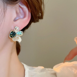 Gros plan détaillé d'une boucle d'oreille fleur vintage avec perles et cristaux sur modèle