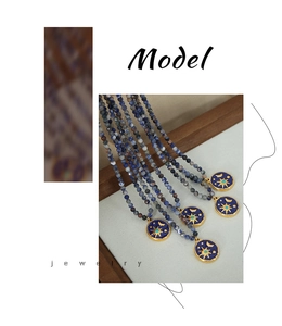 Macro view of blue natural stone bead necklace with a celestial angel sun pendant