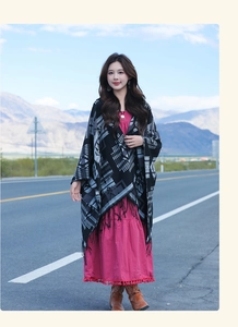 Ethnic black and white geometric shawl with tassels styled on a scenic outdoor highway