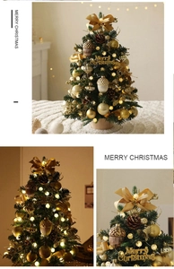 Close-up of mini Christmas tree with gold ornaments, pine cones, and warm LED fairy lights