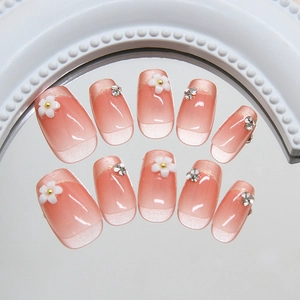 Rosa Ombre-Nägel mit weißen 3D-Blumenblättern und funkelnden Strasssteinen