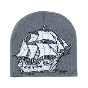 Gros plan du bonnet gris en maille avec motif de voilier jacquard détaillé en noir et blanc