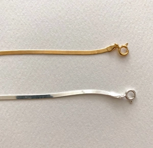 Macro view of gold and silver 925 sterling silver snake chains showing texture and clasps