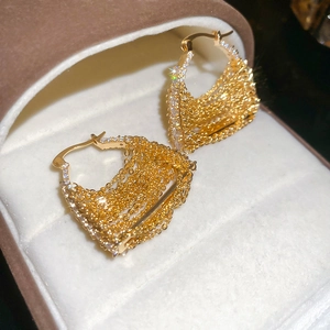 Detail of 18k gold plated chain earrings with sparkling zircon stones in a jewelry box