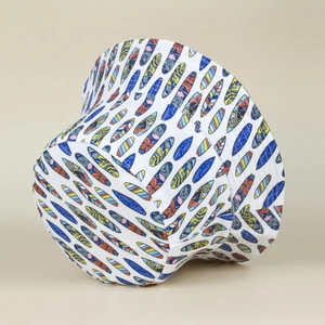 Detail of white bucket hat with colorful surfboard prints and Ocean Calling typography
