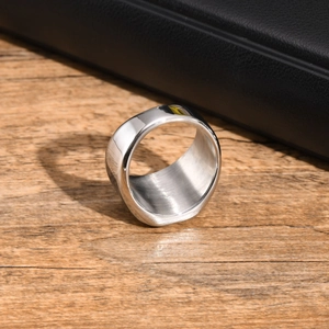 Detail of silver stainless steel ring showing polished surface and brushed inner finish