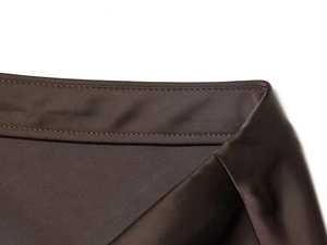 Détails de couture et texture satinée sur la taille de cette jupe midi marron