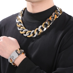 Close-up of hip hop chunky gold and silver steel Cuban link chain necklace and bracelet set