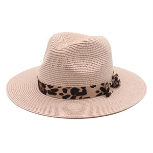 Detail of breathable beige straw fedora featuring a stylish leopard print ribbon and bow