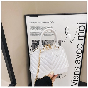 Detail of white jelly shell bag featuring V-texture finish and gold chain strap