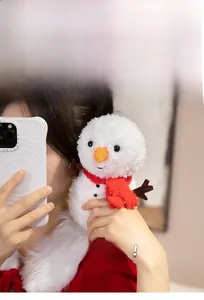 Close-up of a soft snowman plush toy with a red scarf and orange carrot nose detail