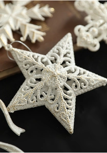 Macro shot of white glitter Christmas star and snowflake ornament with hollow patterns