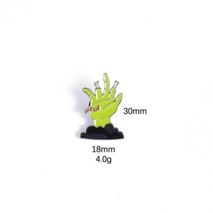 Detail of 30mm zombie hand enamel pin in neon green with size and weight specs