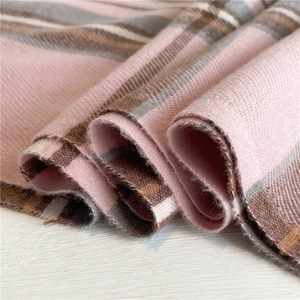 Dettaglio ravvicinato di una sciarpa in finto cashmere con trama a quadri rosa e marroni