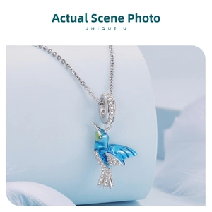 Macro shot of 925 silver hummingbird charm with blue-green enamel and white zircon stones