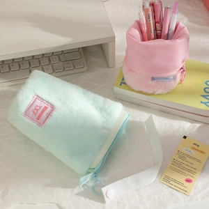Detail of plush telescopic pencil case showing upright stand function in mint and pink