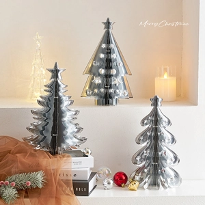 Silver metal origami Christmas trees and glowing tree on white tiered display stand