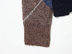 Close-up of ribbed knit cuffs featuring contrasting navy blue and gray argyle patterns