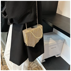 Detail of gold sequin fringe clutch bag with chain strap and luxury box structure