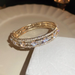 Macro shot of gold-plated bracelet featuring triple-row zircons and round crystal accents