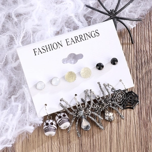 Close-up of Halloween earring set with ghost pumpkin and skull motifs on a web background