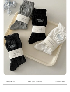Detail of ruffled socks with ribbon bows and Bébé Bonjour embroidery in gray and black