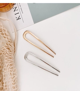 Close-up of gold and silver U-shaped metal hairpins with elegant colorful enamel finish